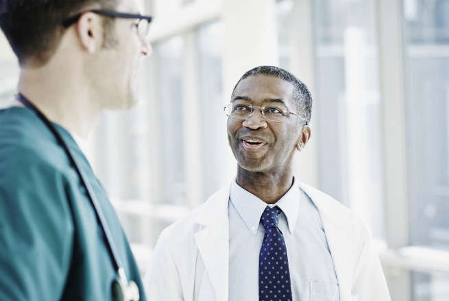 Physicians holding a conversation in the hallway.